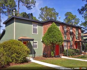 Palatka apartment for rent - a green house with a red door and a tree