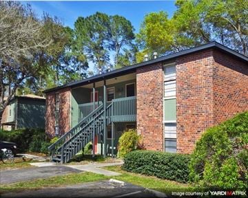 Palatka apartment for rent - a red brick building with a green porch and stairs
