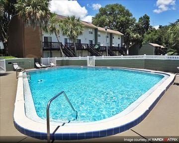 Gainesville apartment for rent - a large swimming pool in front of a building
