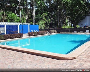 Gainesville apartment for rent - a blue swimming pool with chairs around it