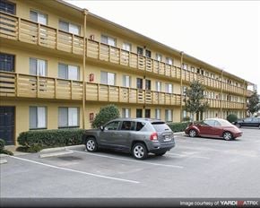 Tallahassee apartment for rent - an apartment building with cars parked in a parking lot