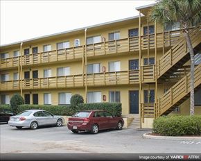 Tallahassee apartment for rent - a yellow apartment building with cars parked in front of it