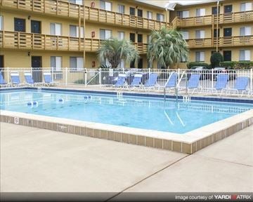 Tallahassee apartment for rent - a swimming pool with blue chairs in front of a hotel