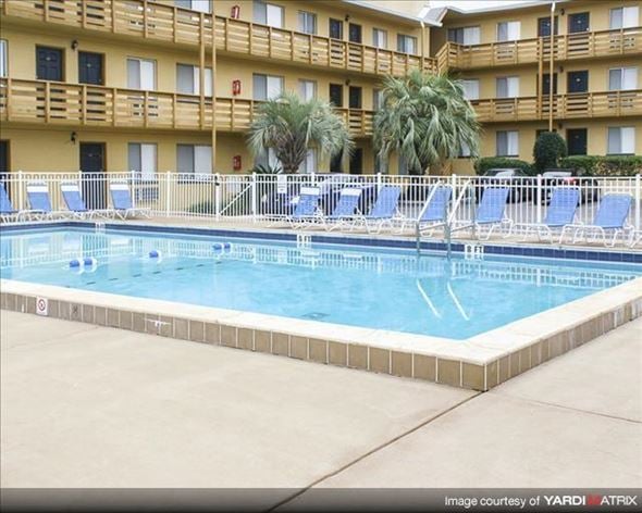 Tallahassee apartment for rent - a swimming pool with blue chairs in front of a hotel