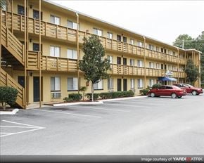 Tallahassee apartment for rent - a large building with cars parked in a parking lot