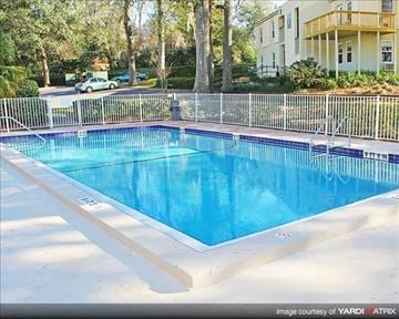Tallahassee apartment for rent - a large blue swimming pool next to a fence