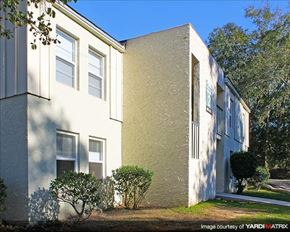 Tallahassee apartment for rent - a white building with trees and bushes in front of it