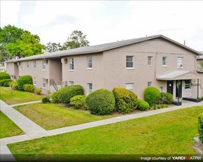Gainesville apartment for rent - a white house with a yard and bushes