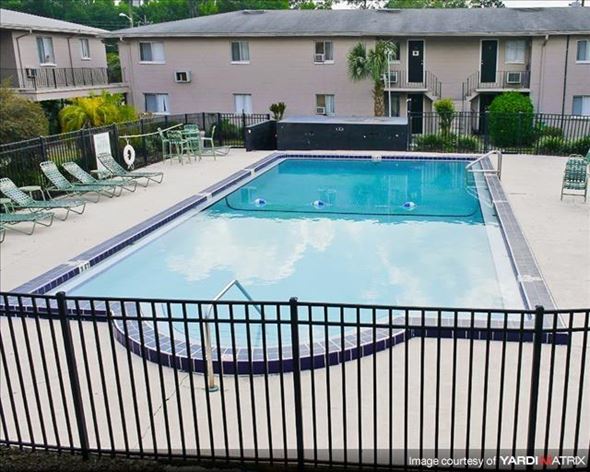 Gainesville apartment for rent - a swimming pool with a wrought iron fence around it