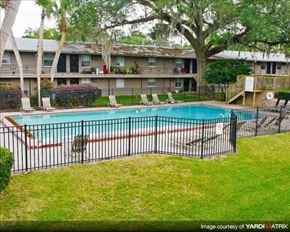 Gainesville apartment for rent - a swimming pool with a wrought iron fence around it