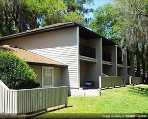 Gainesville apartment for rent - a white house with a porch and a fence