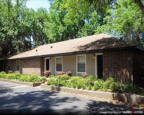 Gainesville apartment for rent - a small brick house with bushes and trees