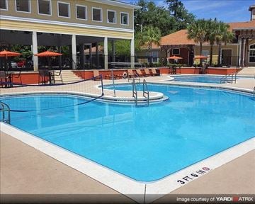 Gainesville apartment for rent - a large blue swimming pool in front of a building