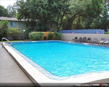 Gainesville apartment for rent - a large swimming pool with chairs around it