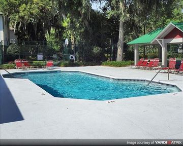 Gainesville townhouse for rent - a swimming pool with red chairs around it