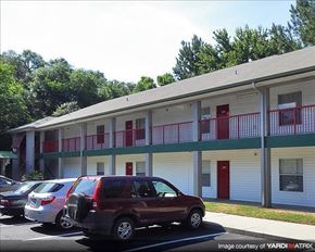 Gainesville townhouse for rent - a building with cars parked in a parking lot