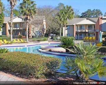 Tallahassee apartment for rent - a large swimming pool with palm trees and houses