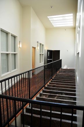 Richmond apartment for rent - a staircase in a building with a black railing and a window