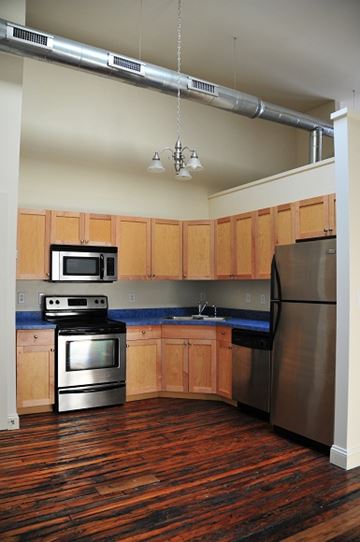 Richmond apartment for rent - a kitchen with stainless steel appliances and wooden cabinets