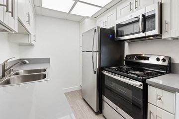 Lake Balboa apartment for rent - a kitchen with a stove refrigerator and microwave  and a sink