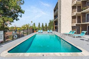 Lake Balboa apartment for rent - a swimming pool in front of an apartment building with lounge chairs