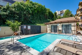 Los Angeles apartment for rent - a swimming pool with two chairs and a building in the background