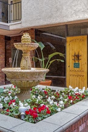 Los Angeles apartment for rent - a water fountain in front of a building with flowers