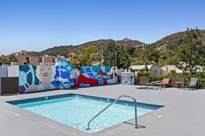 Hollywood apartment for rent - a swimming pool is next to a mural on a wall