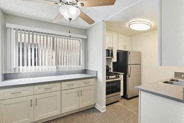 Los Angeles apartment for rent - a kitchen with white cabinets and a refrigerator and a sink