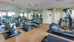 Los Angeles apartment for rent - a gym with cardio machines and weights on a wooden floor