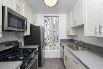 Los Angeles apartment for rent - A kitchen with a black stove top oven and a black microwave.