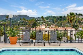 Los Angeles apartment for rent - A pool with chairs and a view of a mountain in the background.