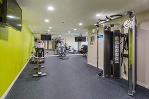 Los Angeles apartment for rent - a gym with weights and cardio equipment in a building with yellow walls