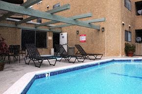 West Hollywood apartment for rent - a swimming pool with chaise lounge chairs next to a building