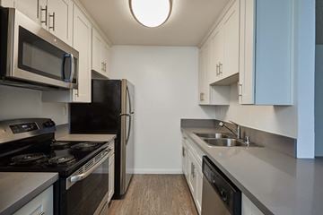 West Hollywood apartment for rent - a kitchen with stainless steel appliances and white cabinets