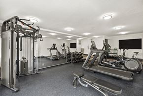 West Hollywood apartment for rent - A black and white photo of a gym with a treadmill, weights, and other exercise equipment.
