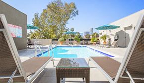 West Hollywood apartment for rent - a swimming pool with chairs and umbrellas on a sunny day