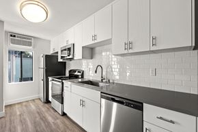 West Hollywood apartment for rent - A modern kitchen with white cabinets and stainless steel appliances.