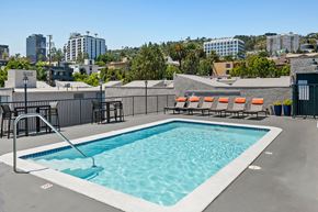 West Hollywood apartment for rent - a pool on the roof of a building with a city in the background