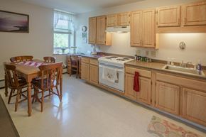 Littleton apartment for rent - a kitchen with wooden cabinets and a table with chairs