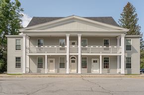 Franconia apartment for rent - the front of a white house with a balcony