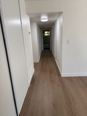 Vallejo house for rent - A long hallway with wood flooring and white walls.