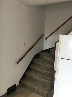 Glassport house for rent - A staircase with a carpeted runner and wooden handrails.