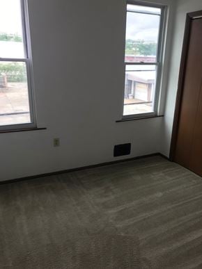Glassport house for rent - A room with a carpeted floor, a window, and a door.