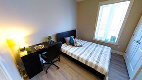 Ottawa apartment for rent - a bedroom with a bed and a desk and a window