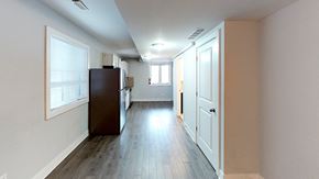 Ottawa apartment for rent - a pass through kitchen and living room with white walls and wood floors