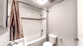 Ottawa apartment for rent - a bathroom with a tub and a toilet and a sink