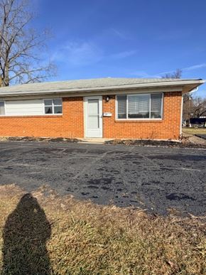 Hilliard apartment for rent - A red brick house with a white door and a shadow of a person in front of it.