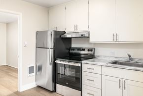 San Francisco apartment for rent - a kitchen with white cabinets and stainless steel appliances and a refrigerator