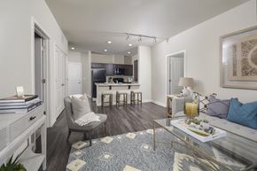 Charlotte apartment for rent - Spacious apartment interior with a combined living and kitchen area, highlighted by an island countertop, barstools, and modern finishes